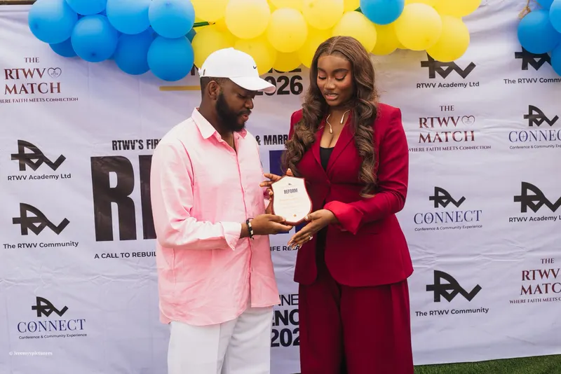 A plaque being presented at the RTWV photo backdrop with balloons