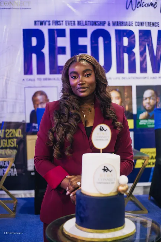 The speaker in a maroon suit standing behind the RTWV Connect cake